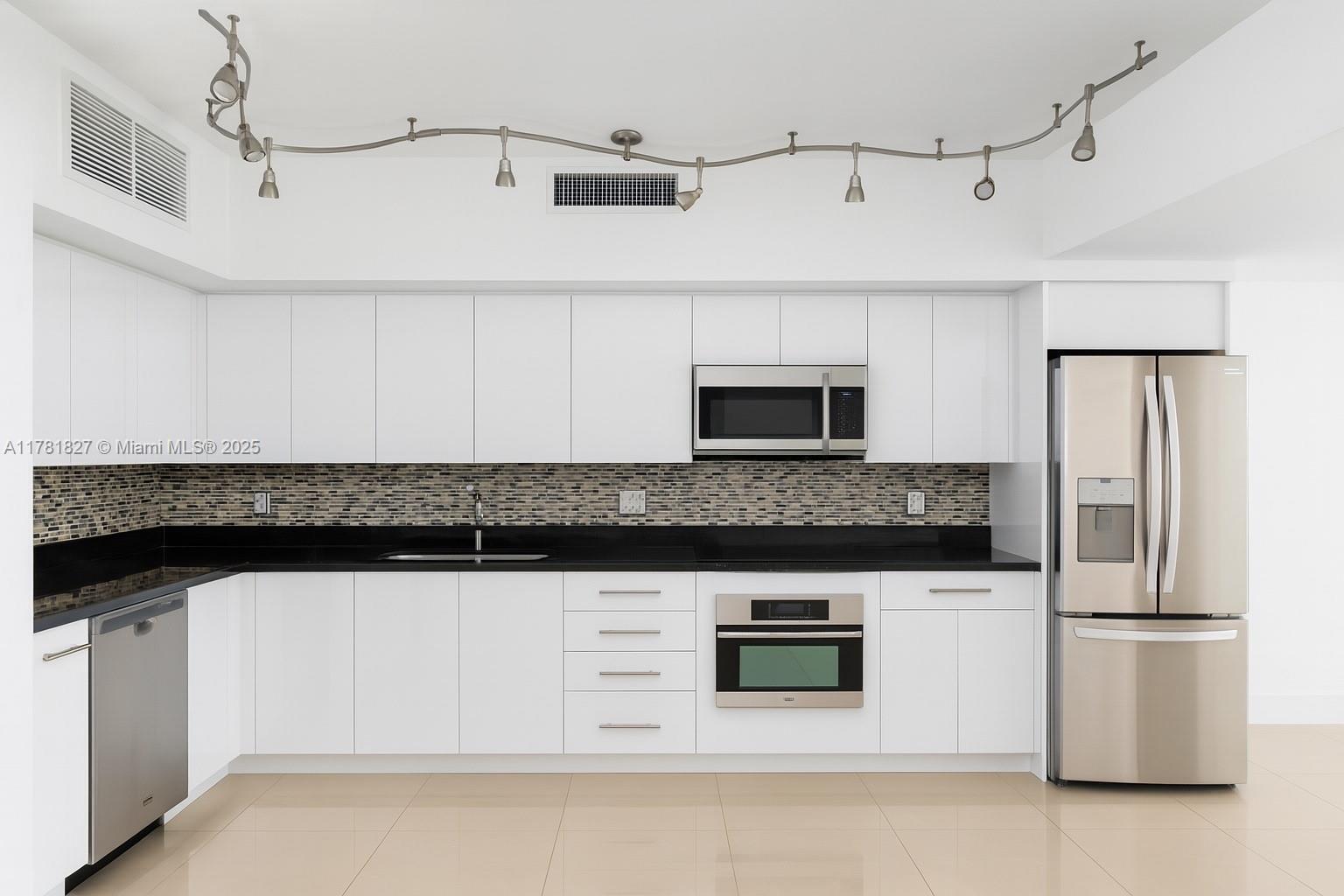 92 Southwest 3rd Street, Unit 4209 Miami, FL 33130 - Photo 3 of 31 a kitchen with stainless steel appliances granite countertop a stove a microwave and a refrigerator