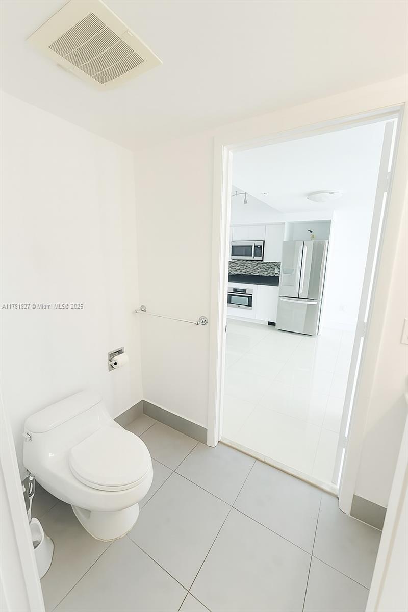 92 Southwest 3rd Street, Unit 4209 Miami, FL 33130 - Photo 9 of 31 a white toilet sitting next to a bathroom sink