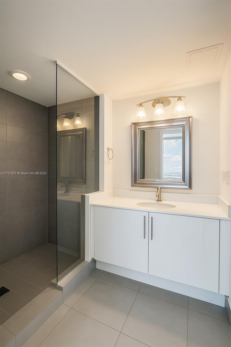 92 Southwest 3rd Street, Unit 4209 Miami, FL 33130 - Photo 10 of 31 a bathroom with a sink a mirror and a bathtub