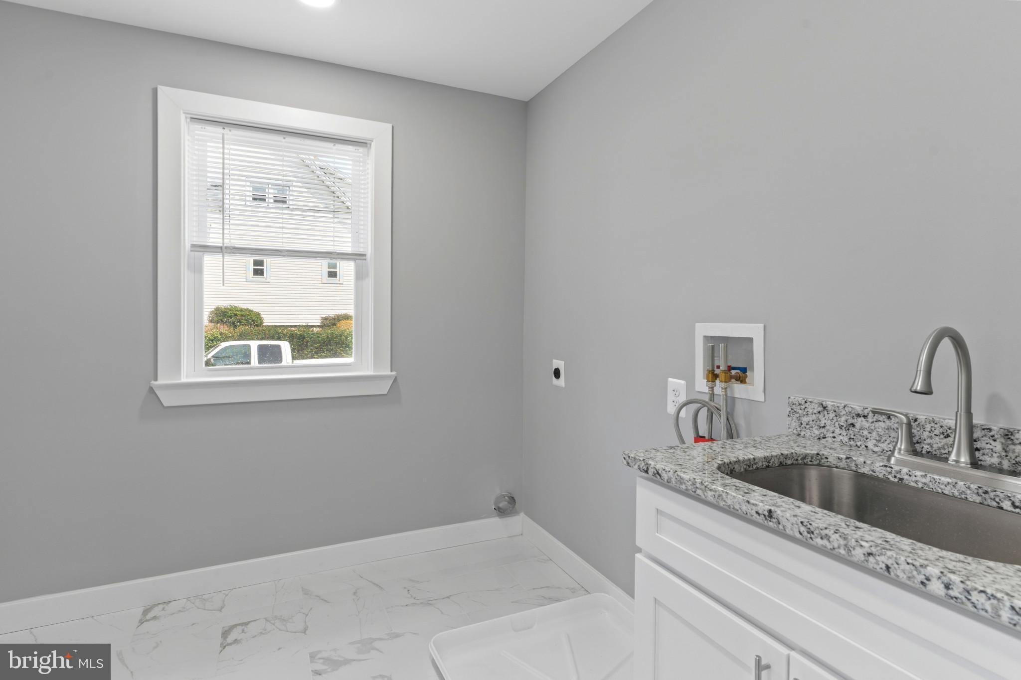 5728 Clover Road Baltimore, MD 21215 - Photo 15 of 40 a bathroom with a granite countertop sink a vanity and window