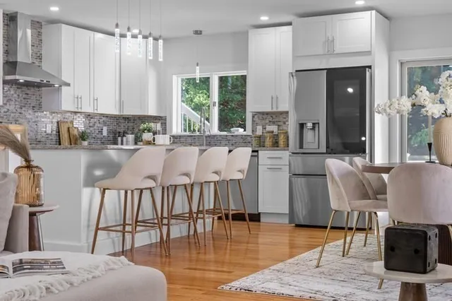 a kitchen with stainless steel appliances granite countertop a stove a sink a dining table and chairs