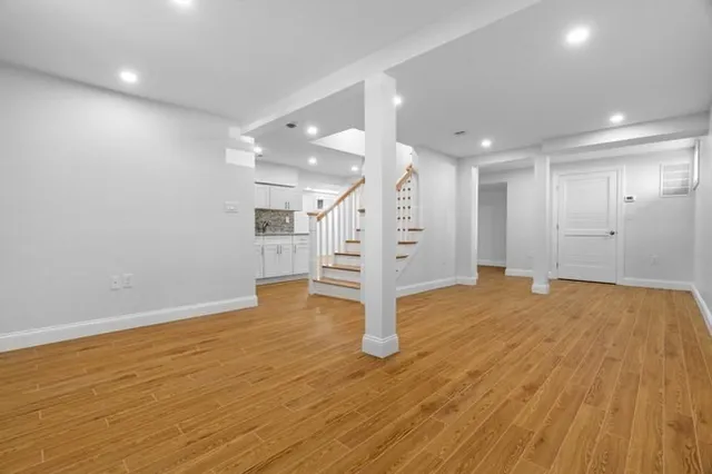 a view of empty room with wooden floor