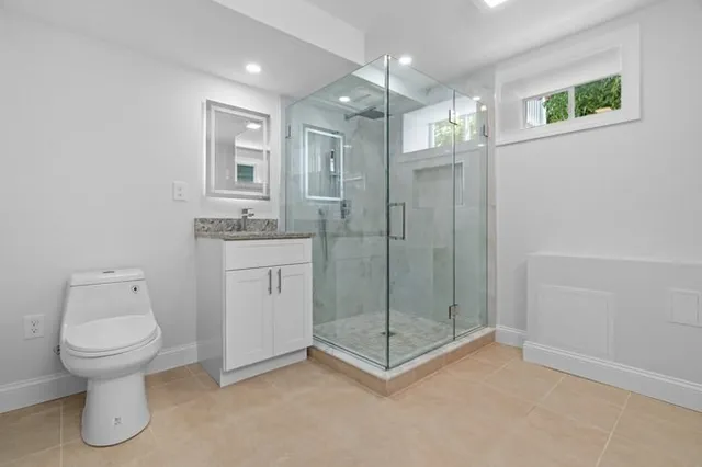 a bathroom with a shower a toilet and a sink