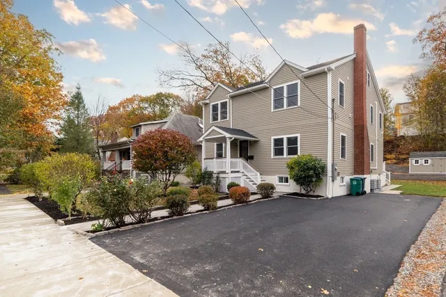 a front view of a house with a yard and potted plants