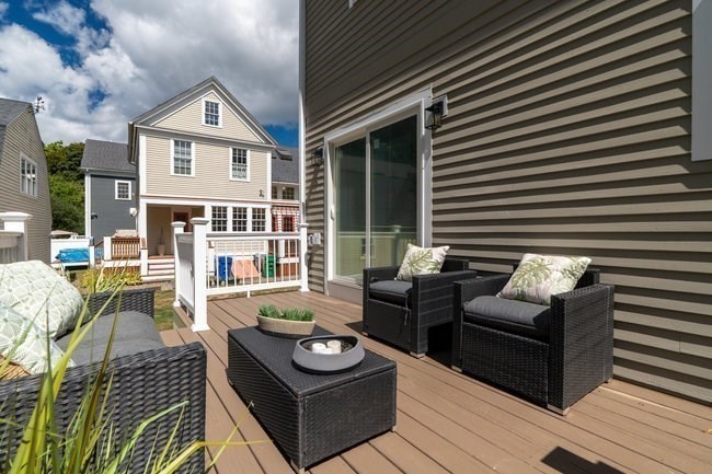 321 Albemarle Road Newton, MA 02460 - Photo 31 of 34 a view of a patio with couches table and chairs with wooden floor and fence