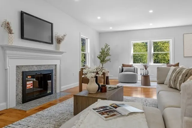 a living room with furniture a fireplace and a flat screen tv