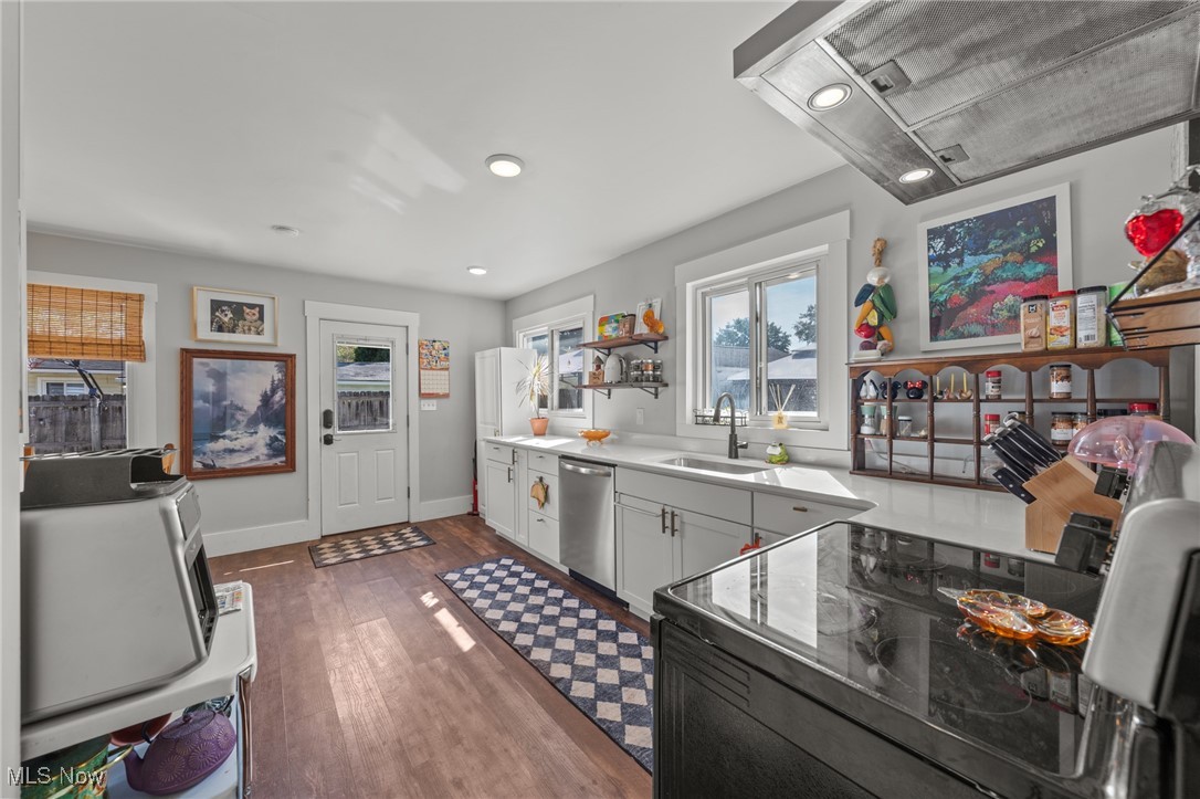 2514 Carson Road Akron, OH 44333 - Photo 9 of 48 Kitchen featuring exhaust hood, dark wood-style flooring, black electric range, stainless steel dishwasher, and recessed lighting