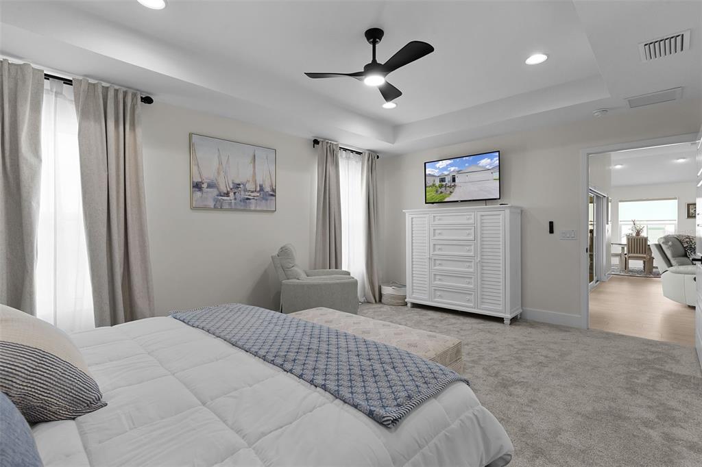 6776 Robinette Run, Unit ROBINETTE RUN The Villages, FL 34762 - Photo 19 of 52 a bedroom with a large bed and a chandelier