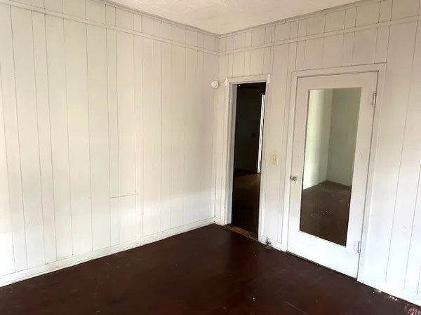 a view of a small space with wooden floor and a hallway
