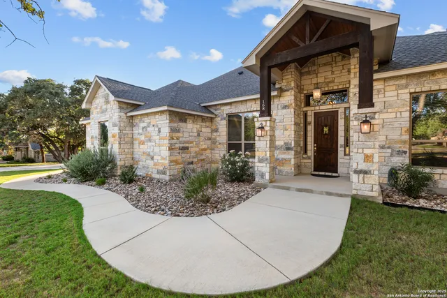 a view of a house with a yard potted plants and a bench