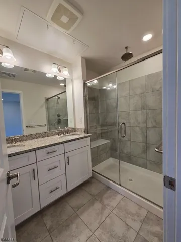 a bathroom with a shower sink and mirror