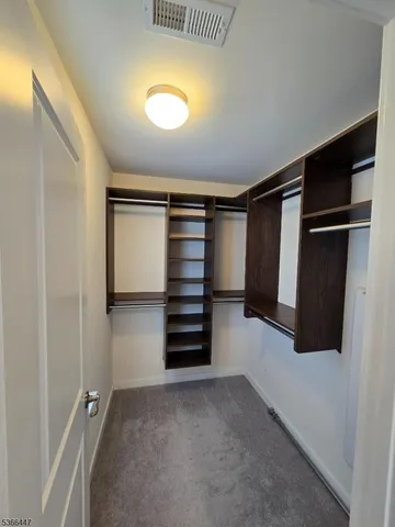 a view of walk in closet with clothes