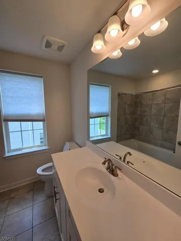 a bathroom with a tub sink and mirror