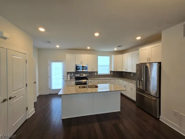 a kitchen with stainless steel appliances a refrigerator and a stove top oven