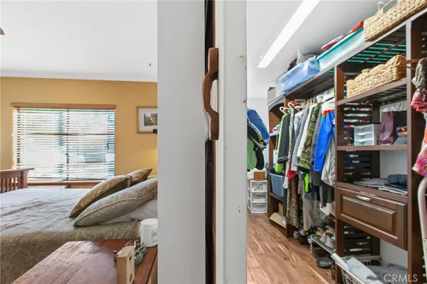 a view of walk in closet with clothes and shoes
