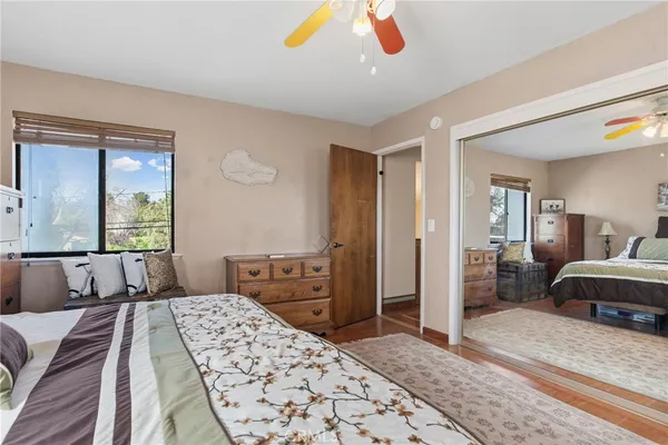 a bedroom with a bed and dresser with mirror