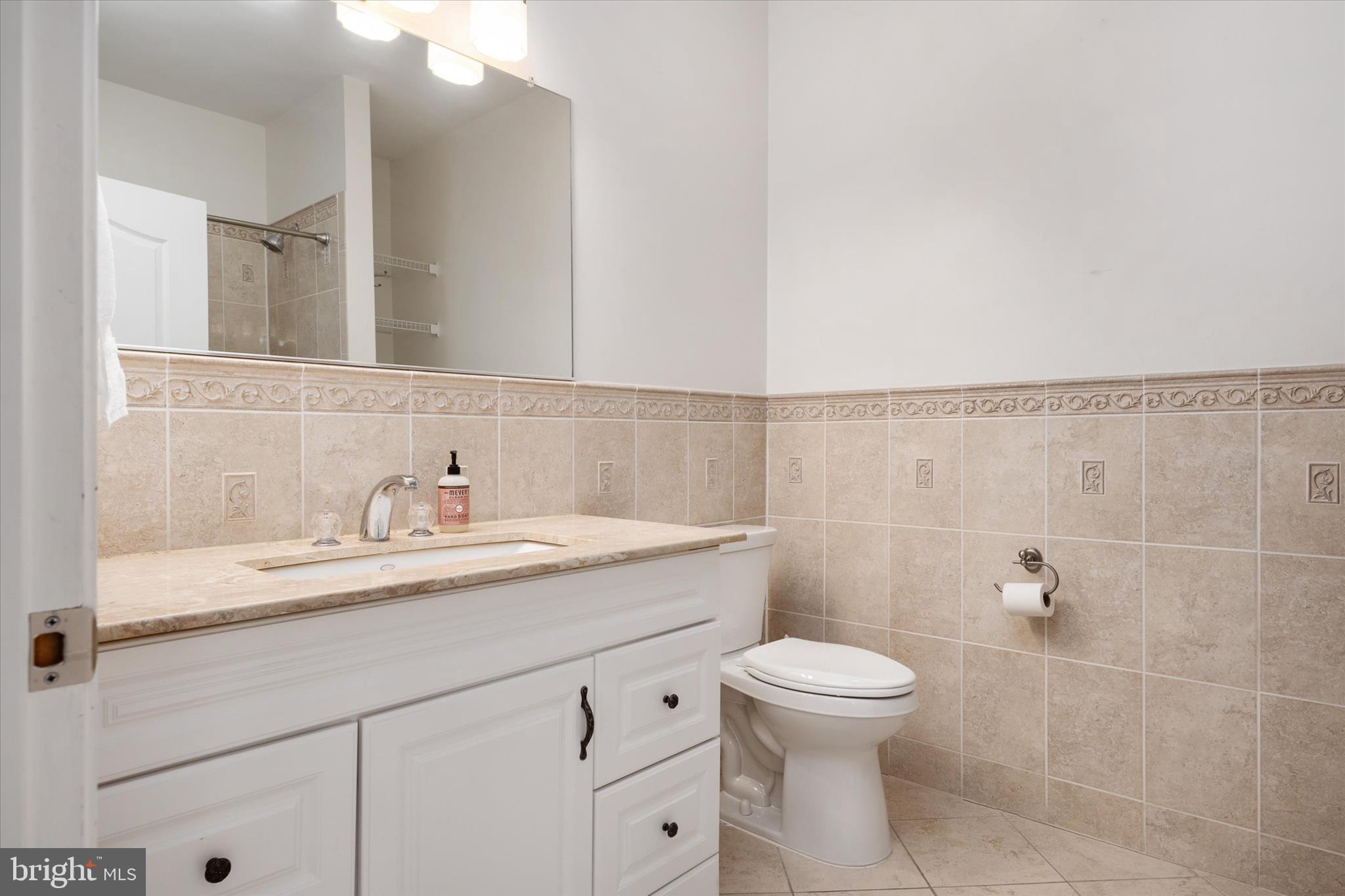 730 Central Avenue East Edgewater, MD 21037 - Photo 29 of 63 a bathroom with a granite countertop sink a toilet and a mirror