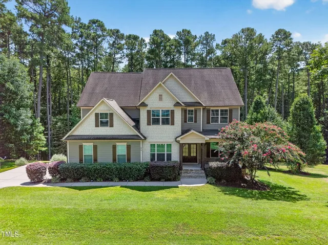a front view of a house with a yard and trees