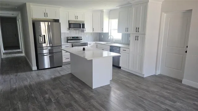 a kitchen with stainless steel appliances granite countertop a refrigerator oven a sink and dishwasher