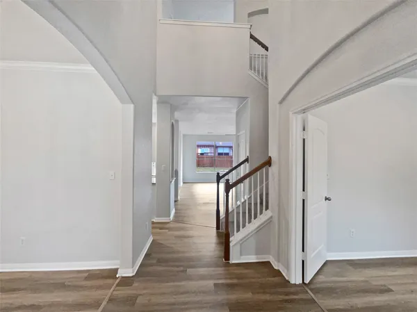 a view of a hallway with wooden floor and staircase