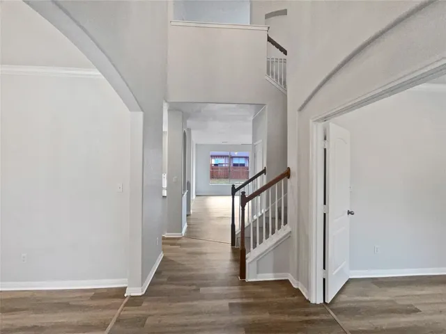 a view of a hallway with wooden floor and staircase