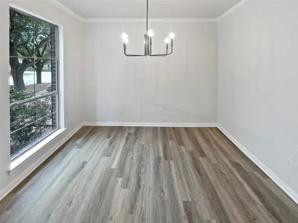 a view of a room with wooden floor next to a window