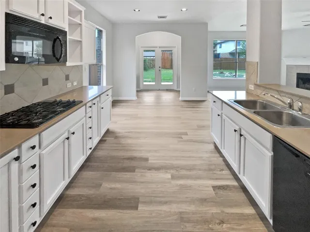 a large white kitchen with granite countertop lots of counter top space