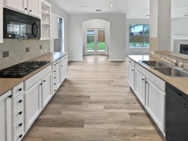 a large white kitchen with granite countertop lots of counter top space