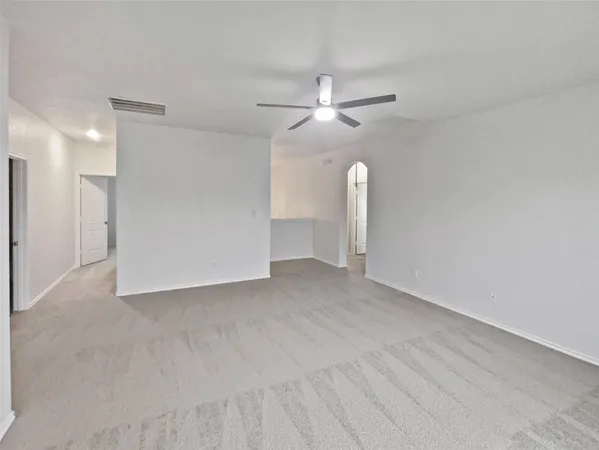 a view of an empty room with a ceiling fan