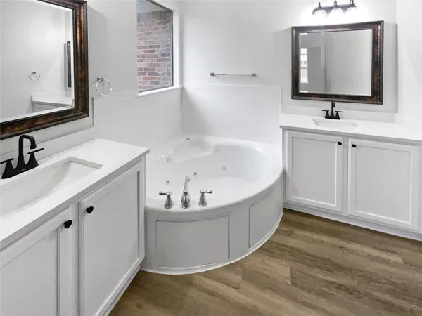 a bathroom with a bathtub sink and mirror