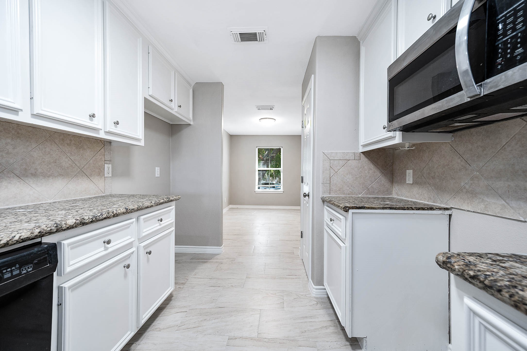 7308 Avenue R Galveston, TX 77551 - Photo 10 of 24 a kitchen with stainless steel appliances granite countertop a stove and a microwave