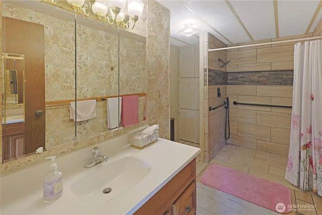 a bathroom with a sink a toilet and shower