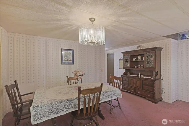 a view of a dining room with furniture and chandelier
