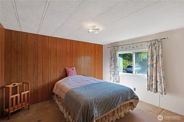 a bed sitting in a bedroom next to a window