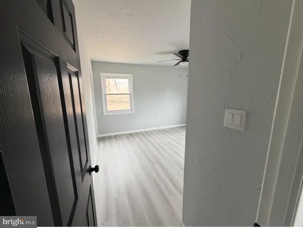 an empty room with wooden floor and a window