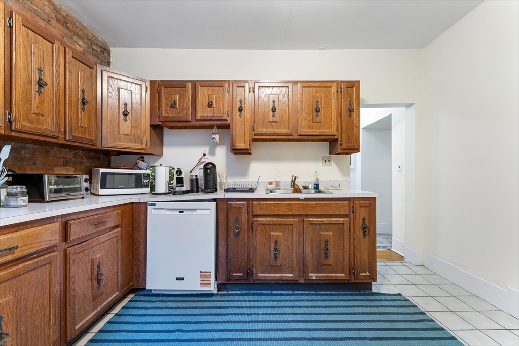 1408 Commonwealth Avenue, Unit 14 Boston, MA 02135 - Photo 8 of 12 a kitchen with stainless steel appliances granite countertop a sink and cabinets