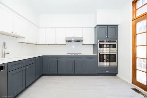 a kitchen with a refrigerator sink and cabinets