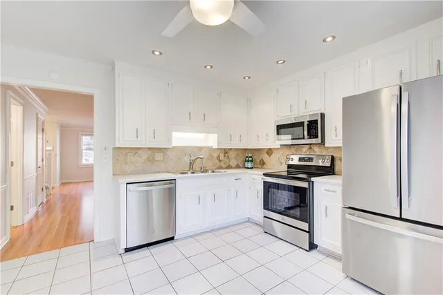a kitchen with white cabinets stainless steel appliances and a sink