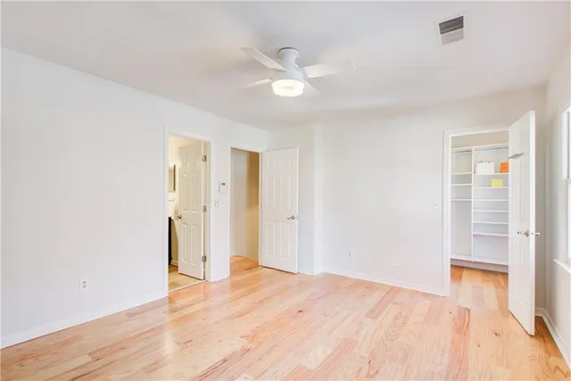 a view of a room with wooden floor and a ceiling fan