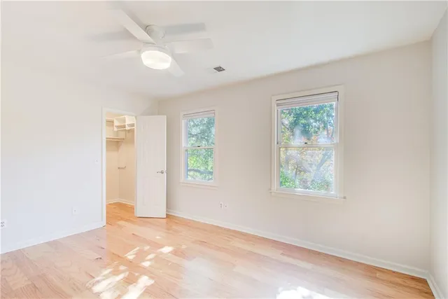 a view of a room with wooden floor and a ceiling fan