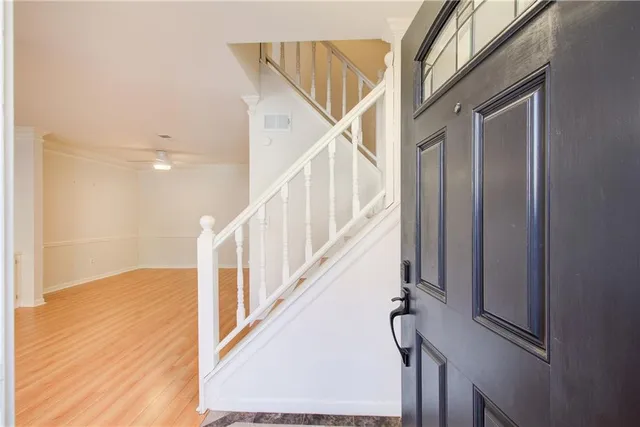 a view of staircase with lots of frames on wall and wooden floor