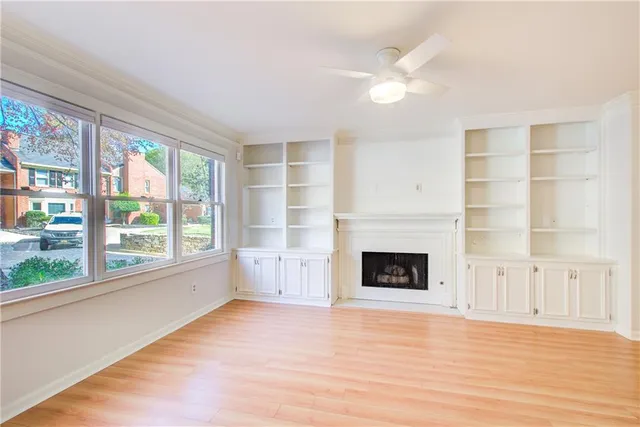a view of an empty room with a fireplace and a window