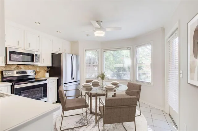 a view of a dining room with furniture a kitchen and chandelier
