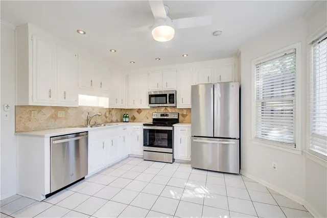 a kitchen with cabinets stainless steel appliances and a window