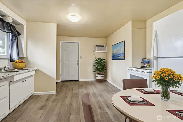 a living room with stainless steel appliances furniture a couch and a potted plant