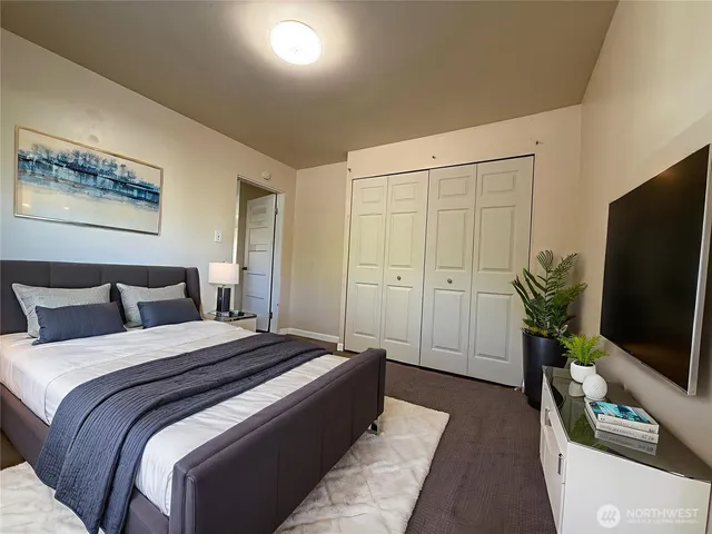 a bedroom with a bed and a flat screen tv