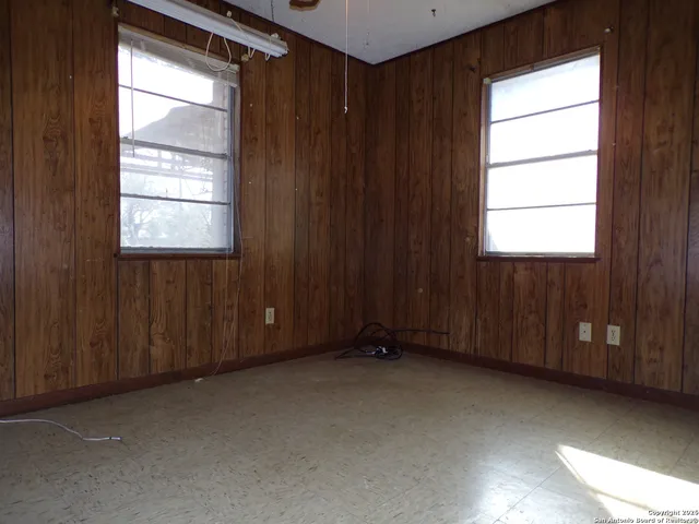 a view of an empty room with closet and wooden door