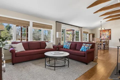 a living room with furniture a large window and a table