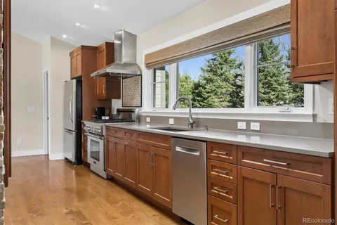 a kitchen with stainless steel appliances granite countertop a sink a stove and a refrigerator