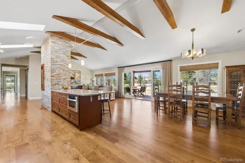 a large white kitchen with lots of counter space and dining table